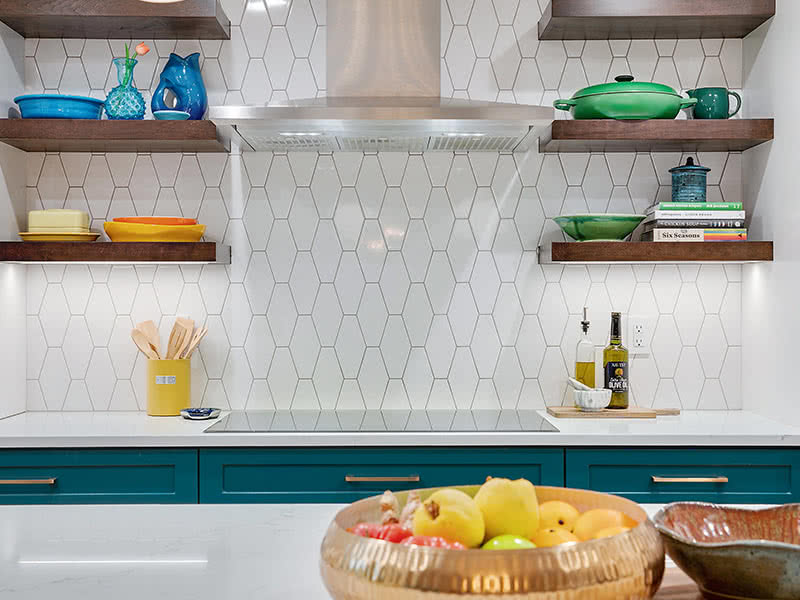White mid-century tiles behind kitchen cooktop and floating shelves