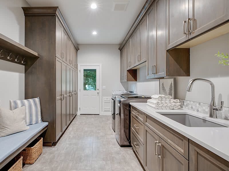 The mudroom and laundry room serve as a dual-purpose drop-off zone and laundry room with built-in cabinets for extra storage.