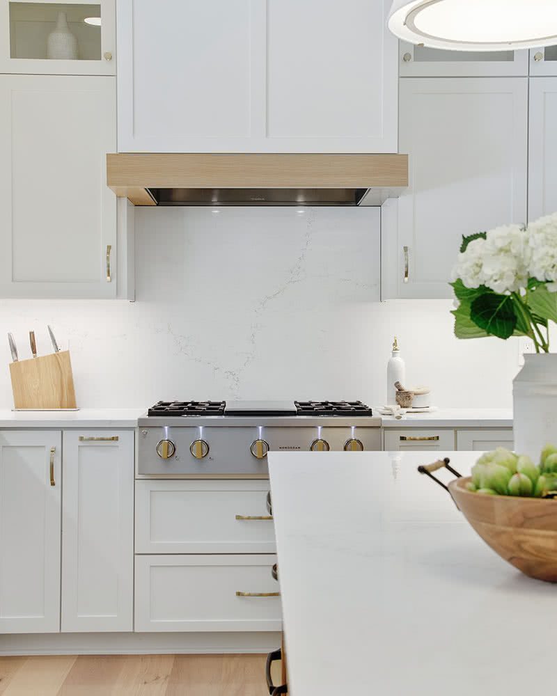 Painted white kitchen cabinets with cabinet hood and contrasting white oak band in this Portland kitchen remodel