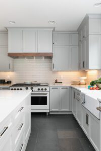 Painted kitchen cabinets with under cabinet hood with contrasting band.