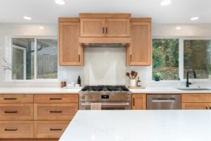 Kitchen with custom wood cabinets and cabinet hood against the solid surface backsplash.