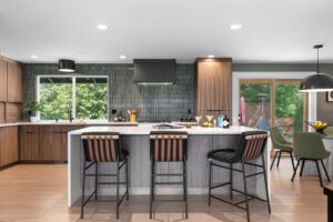 Modern kitchen with range hood against vertical green backsplash tile.