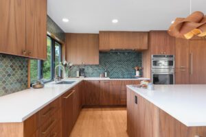 Midcentury modern kitchen with custom walnut cabinets and green backsplash tile.